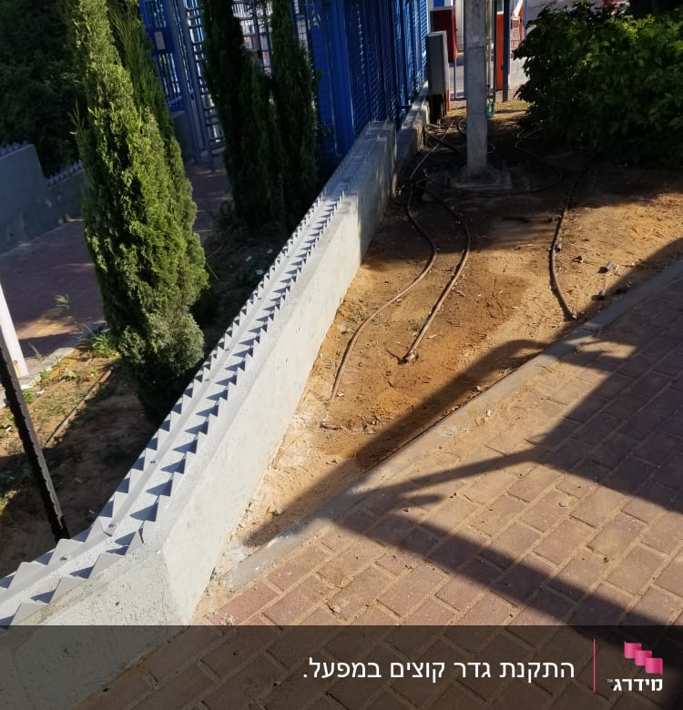 גדר מתכת כחולה עם מסגרת בטון אפורה